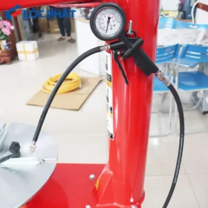 Đồng hồ đo áp suất và súng bơm hơi đi kèm trên trụ đứng máy Alpha AL-800.