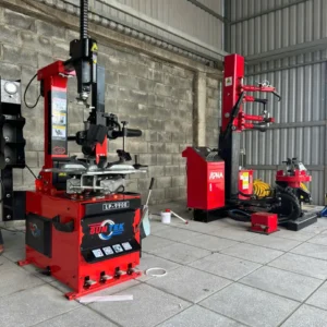 Máy tháo vỏ xe du lịch SunTek LP-990E đặt trong môi trường gara thực tế, cạnh máy nén khí.
