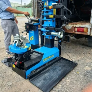 Kỹ thuật viên thao tác tay trang điều khiển máy tháo lốp lưu động Alpha AL-1300-SDL2 vươn ra ngoài xe tải
