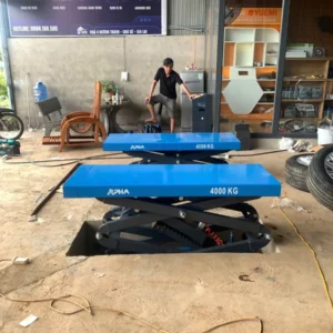 Kỹ thuật viên kiểm tra vận hành tủ điều khiển cầu nâng ô tô kiểu xếp âm nền ALPHA AL-4XA